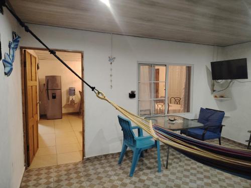 Casa Wili Taboga في تابوغا: أرجوحة في غرفة مع طاولة وكرسي