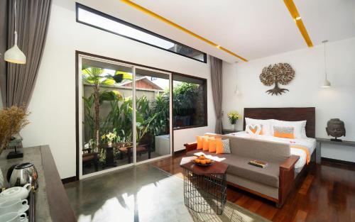 Un dormitorio con una cama, un sofá y una mesa. en The Calm Oasis, en Siem Reap