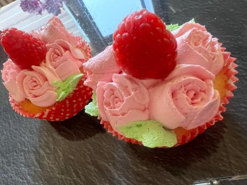 two cupcakes with strawberries on top on a table at Apartament in Bürstadt