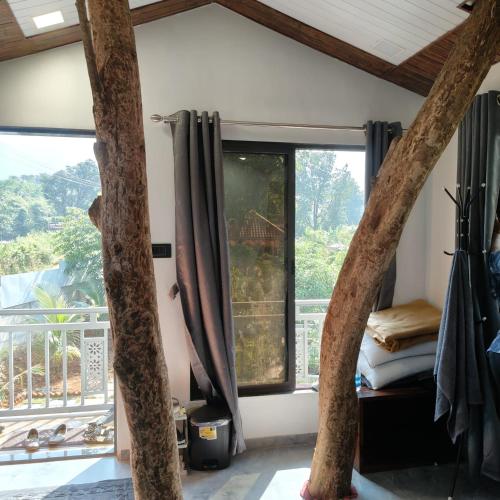 a room with a bed and a large window at The KaMP in Murbād