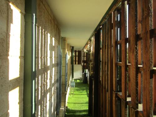 an alley in an old building with green grass at Santa lodge in Armadale