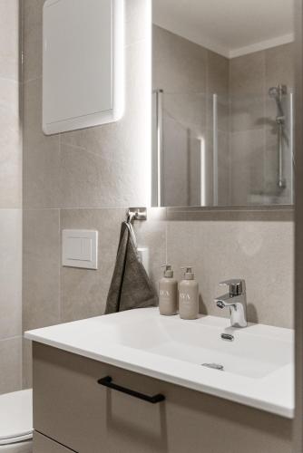 a bathroom with a white sink and a mirror at Motoppen Trysil Apartments in Trysil