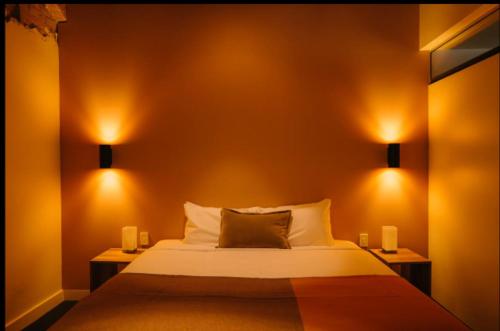 a bedroom with a bed with two lights on it at Gibson Mill waterfront warehouse apartment - 101 in Hobart