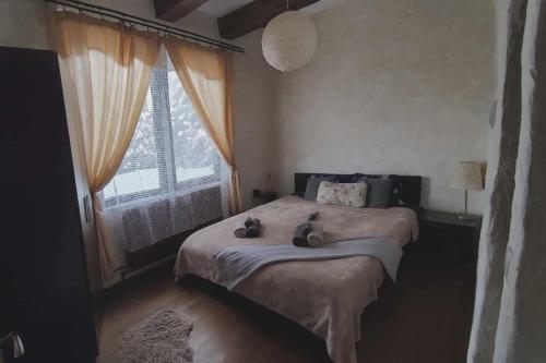 a bedroom with a bed with two stuffed animals on it at Bellevue Beam House in Covasna