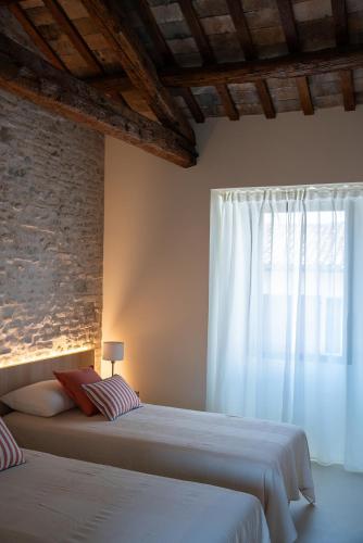 a bedroom with two beds and a window at Attico Malatesta in Rimini