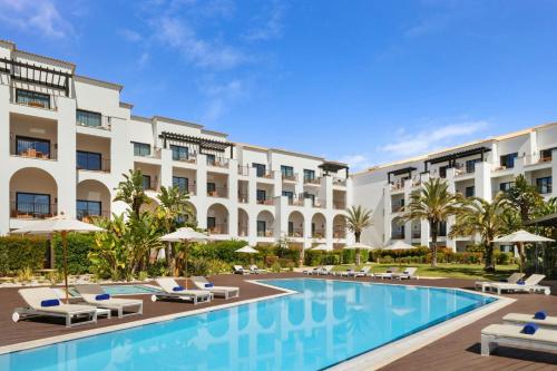 an image of a hotel with a swimming pool at Pine Cliffs Ocean Suites, a Luxury Collection Resort & Spa, Algarve in Albufeira
