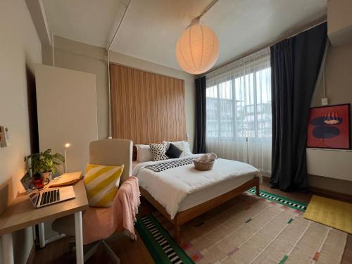 een slaapkamer met een bed, een bureau en een raam bij Office 3 in Bangkok