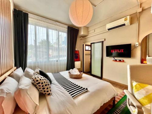 een slaapkamer met een bed met kussens en een raam bij Office 3 in Bangkok