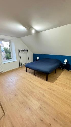 - une chambre avec un lit bleu dans une pièce dotée de parquet dans l'établissement Cosy 6 - Belfort centre, à Belfort