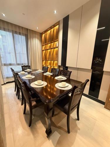 a dining room with a large wooden table and chairs at Excellence Apartment شقه التميز في المونسيه in Riyadh