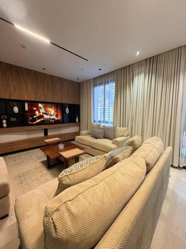 a living room with a couch and a tv at Excellence Apartment شقه التميز في المونسيه in Riyadh