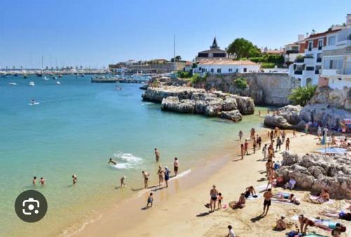 eine Gruppe von Menschen an einem Strand im Wasser in der Unterkunft Home Place Cascais Estoril in Cascais