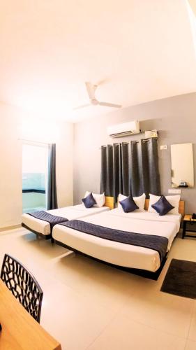a bedroom with a large bed with blue pillows at Blessings Prime Porur - Near DLF in Chennai