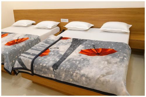 two beds in a room with butterflies on them at Hotel Premium IN Tulsi GH Near Shri Mahakaleshwar Jyotirlinga Temple - Fully Air Air Conditioning Rooms - Prime Location in Ujjain