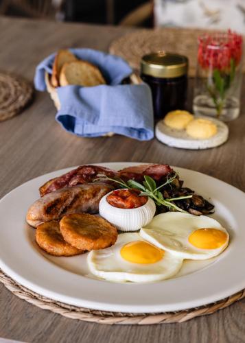 a plate of food with eggs and bread on a table at Diaz Ocean View Hotel & Spa in Mossel Bay