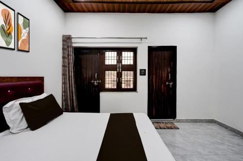 Una cama o camas en una habitación de Hotel O Ganga Royal Guest House