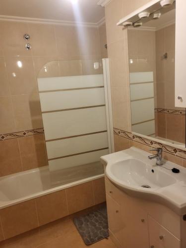 ein Badezimmer mit Waschbecken, Badewanne und Spiegel in der Unterkunft Piso nuevo y acogedor! in O Porriño