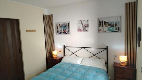 a bedroom with a blue bed and three pictures on the wall at Agriturismo La Terrazza in Valfabbrica
