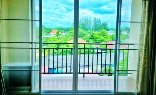 een open raam met uitzicht op een balkon bij SDDP Apartment in San Kamphaeng