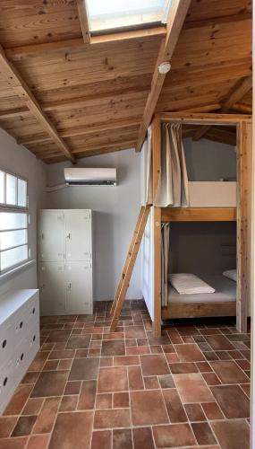 a bunk bed in a room with a brick floor at 都蘭小星民宿 Dulan Star Guest House in Donghe