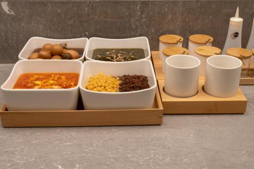 Twee houten dienbladen met schalen eten op een tafel. bij JI Hotel Chengdu Qingbaijiang Phoenix Lake in Chengdu