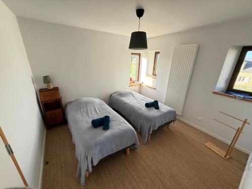 two beds in a room with blue pillows at Le Pressoir, maison au calme, jardin, terrasse, 3 chambres, 2 sdb, 2 WC, proche Bayeux et Arromanches au coeur des plages du débarquement in Longues-sur-Mer