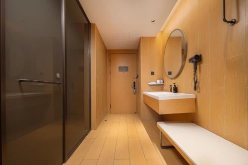 een badkamer met douche, wastafel en spiegel bij JI Hotel Chengdu Qingbaijiang Phoenix Lake in Chengdu