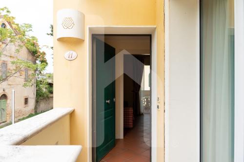 un corridoio di un edificio con porta verde di Homiday - Villa Rosella a Roseto degli Abruzzi