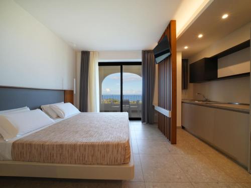 a bedroom with a bed and a view of the ocean at LUZIA AGRIRESORT - Piscina Panoramica e vista Mare a Capo Vaticano in Capo Vaticano