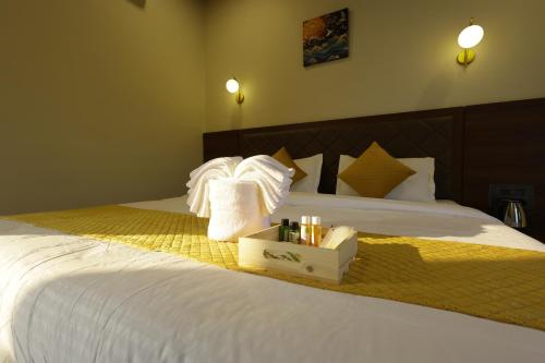 Serenova Resort by ILIF Hotels في مورود: غرفة فندق بها سرير أبيض وعلبة مناشف