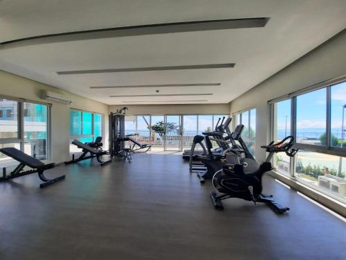 Un gimnasio con cintas de correr y elípticas en un edificio con ventanas. en The UrbanNest, en Piapi