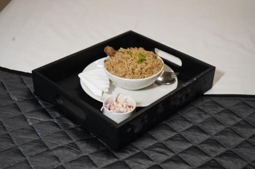 a black box with a bowl of rice and a plate of food at Inn34 By Blessings Hospitality - Porur Near DLF in Chennai
