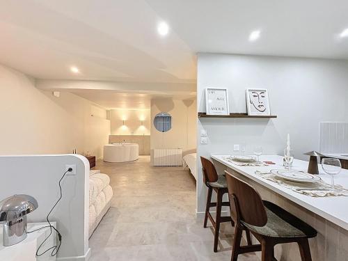 une cuisine et un salon avec une table et des chaises dans l'établissement Douce escapade - Baignoire balnéo, à Brest