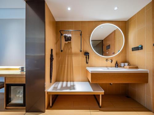 ein Badezimmer mit Waschbecken und Spiegel in der Unterkunft JI Hotel Chengdu Sichuan Normal University in Chengdu