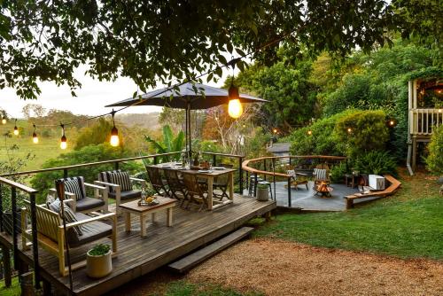 a wooden deck with a table and an umbrella at Doomben Ridge Farm House in Beechmont