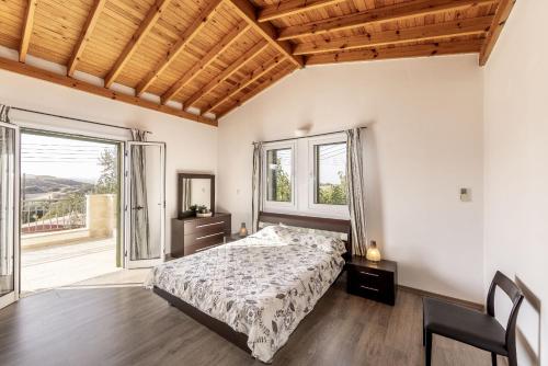a bedroom with a bed and a large window at Rhodia Villa in Ayios Isidhoros