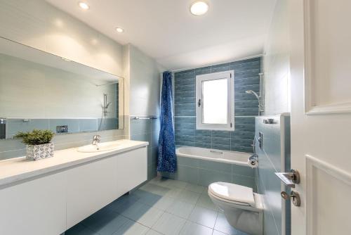 a bathroom with a toilet and a sink and a tub at Rhodia Villa in Ayios Isidhoros