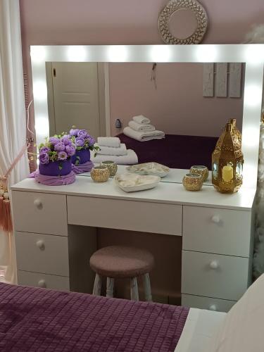 a dressing table with flowers on it in front of a mirror at DreamHouse in Nafpaktos
