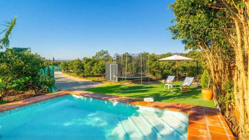 a swimming pool in the yard of a house at Villa Rocío, Acogedora villa con piscina de agua salada en Vélez Málaga in Almayate Alto