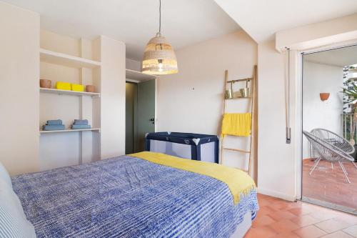 a bedroom with a bed with a blue and yellow blanket at Apartamento Davasa in Armação de Pêra