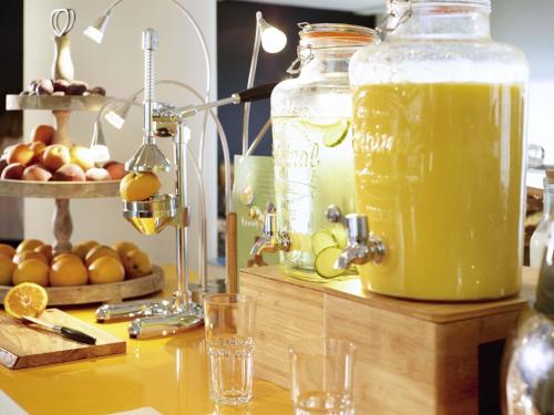 a table with a jar of orange juice and glasses at Novotel York Centre in York
