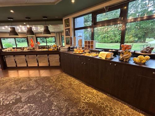 una gran cocina con bufé de comida. en Novotel Bayeux, en Bayeux