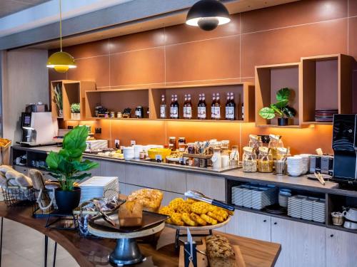 ブールジュにあるNovotel Bourgesの食べ物が置かれたカウンターのあるレストラン