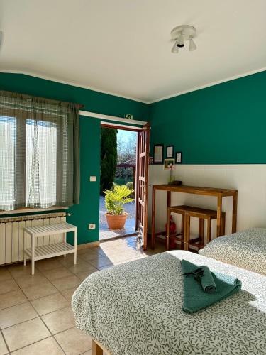 a bedroom with two beds and a green wall at Studio Apartma Olive, Nova Gorica, Slovenia in Nova Gorica