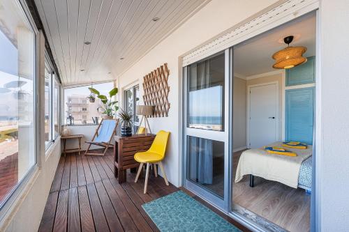 a room with a balcony with a bed and a desk at Charming Beachside Escape in Esmoriz