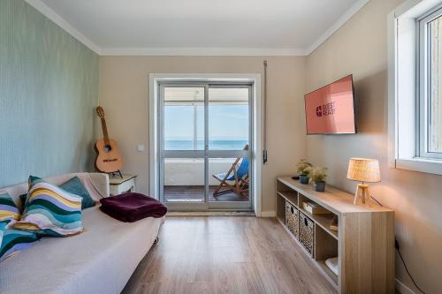 a living room with a couch and a guitar at Charming Beachside Escape in Esmoriz