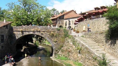a group of people standing in the water under a bridge at Apartamento El Nial de Potes in Potes