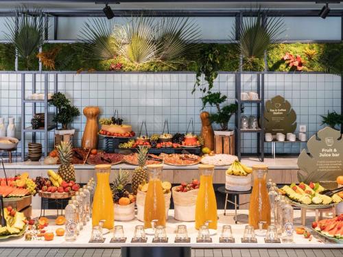 um buffet com frutas e legumes à mostra em Novotel Campo De Las Naciones em Madrid