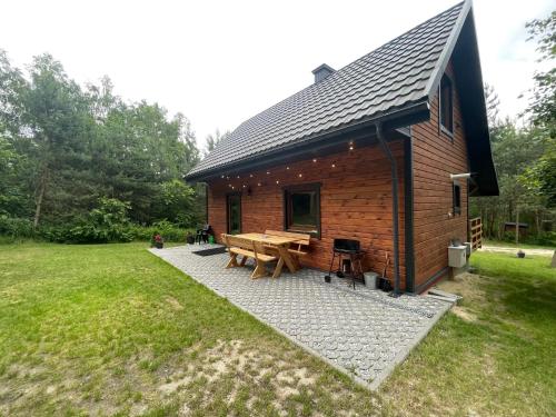 a log cabin with a picnic table in a yard at Domek na Zagórze - domek całoroczny in Krasnobród