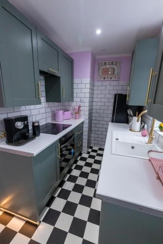 a kitchen with blue cabinets and a checkered floor at Checkered Wonderland at 19 Milbanke in Doncaster